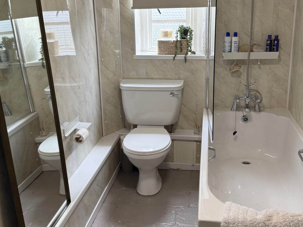 A bathroom with a toilet and bathtub at Cotswolds Castle Sleeps 8 with Enclosed Garden in Banbury