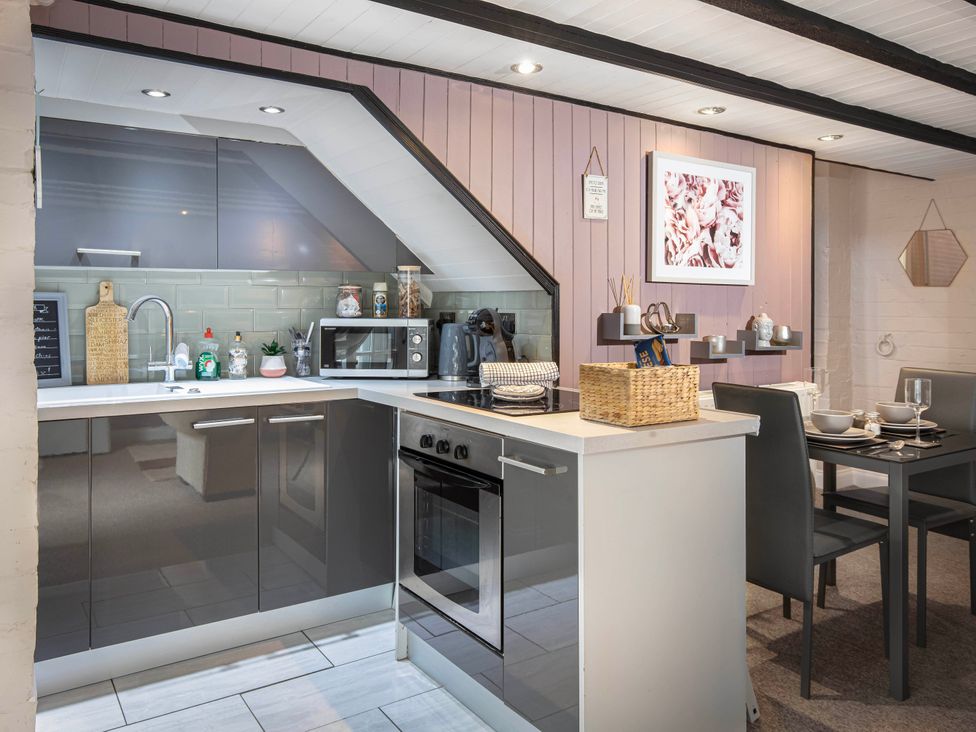 A kitchen with appliances and dining area at Cottage Sleeps4 PetFriendly Garden ByBeach in Lytham St Annes
