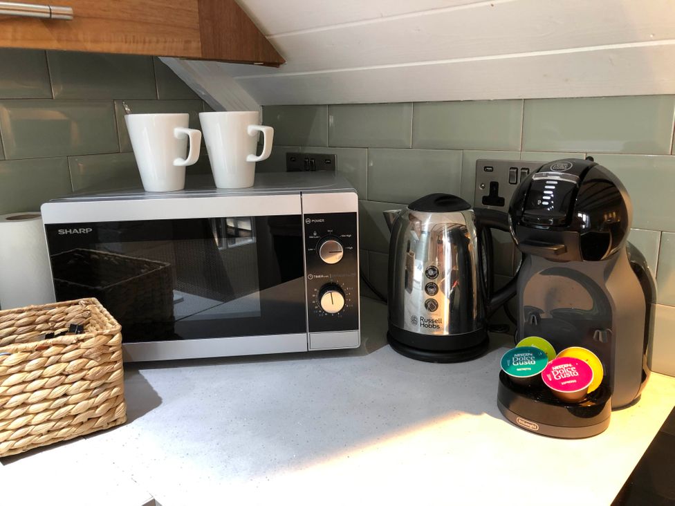 A kitchen counter with a microwave, kettle, coffee machine, and mugs at Cottage Sleeps4  PetFriendly  Garden  ByBeach in Lytham St Annes