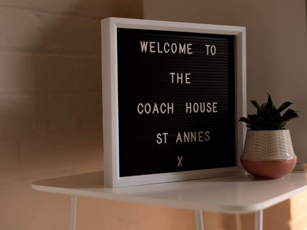 A welcome sign and a plant on a table at The Coach House in St Annes