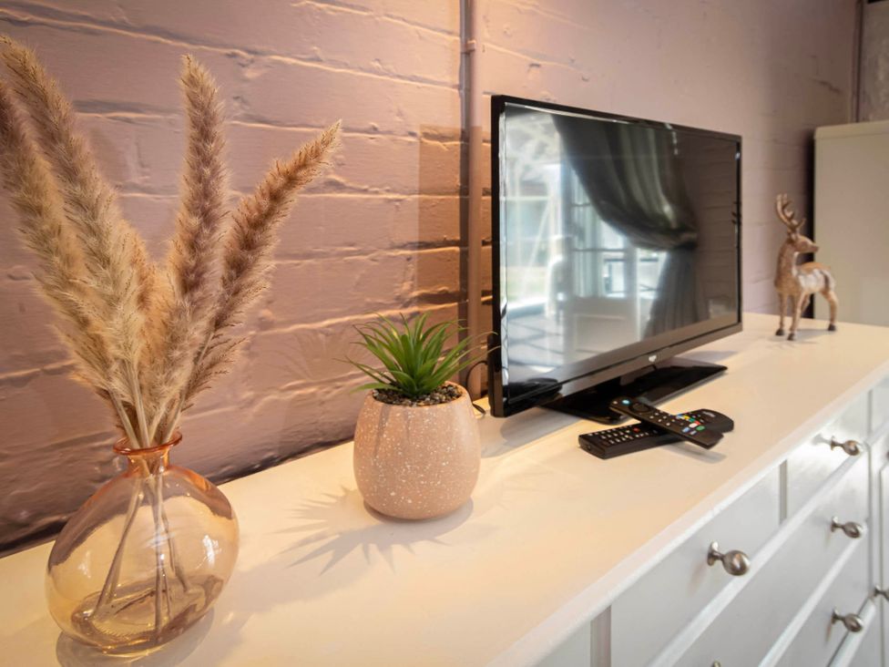 A living room with a television and decorative items at Cottage Sleeps4  PetFriendly  Garden  ByBeach Lytham St Annes