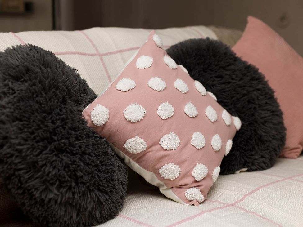 A couch with decorative pillows at Cottage Sleeps4  PetFriendly  Garden  ByBeach in Lytham St Annes