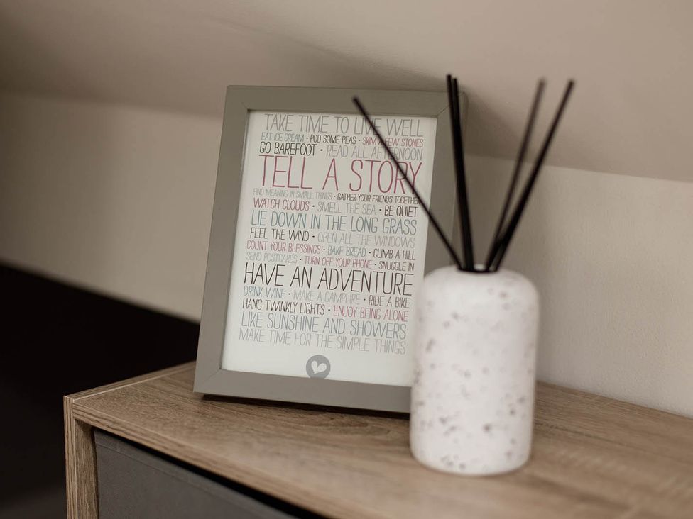 A decorative picture frame and a vase on a wooden cabinet at Cottage Sleeps4 PetFriendly Garden ByBeach Lytham St Annes