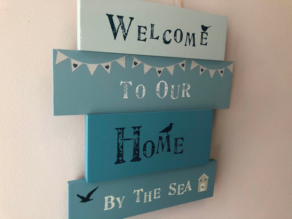 A decorative sign that says Welcome To Our Home By The Sea
