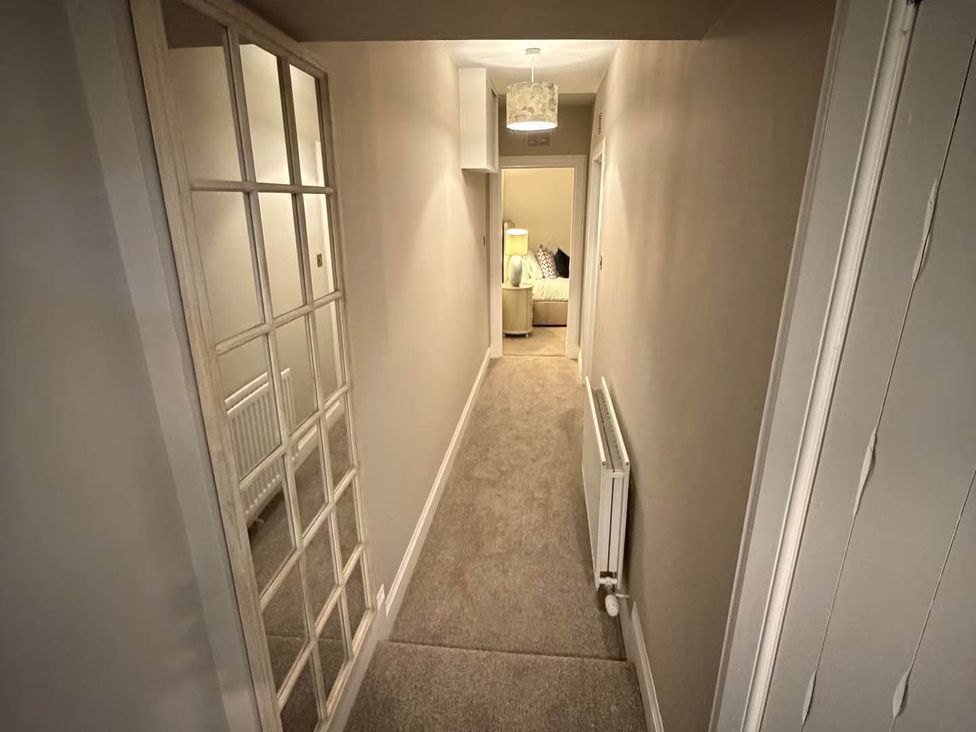 A hallway with doors and a radiator at 2 Bed Cottage Sleeps 4 Parking Wifi Darnick