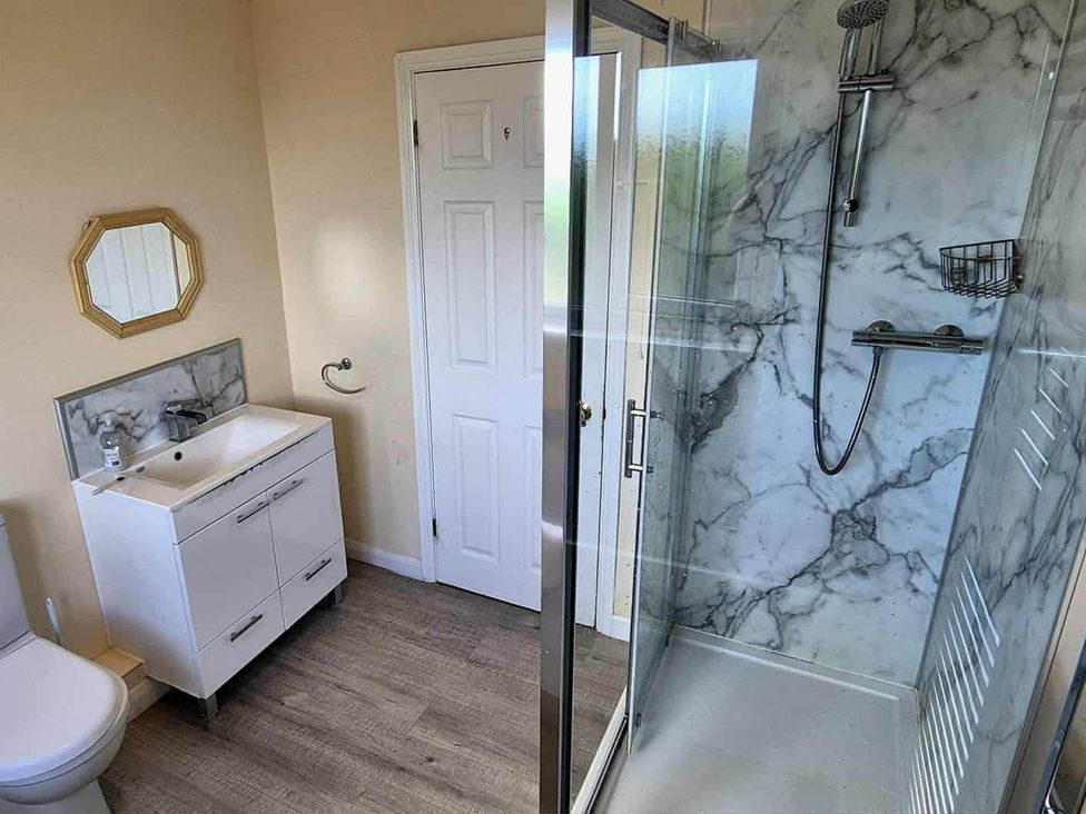 A bathroom with a vanity sink, toilet and shower at Porthleven Coastal Retreat with 5 Bedrooms in Porthleven