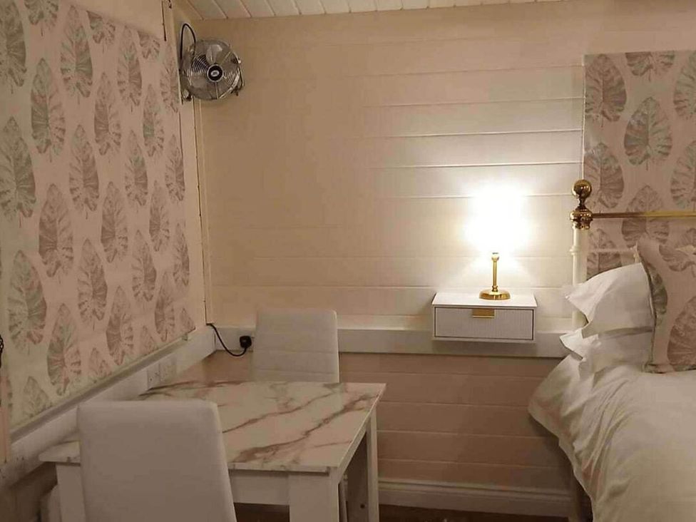 A bedroom with a bed, nightstand, lamp, table and chairs at 1 Bed Lodge Southampton Sleeps 2 Parking, Southampton