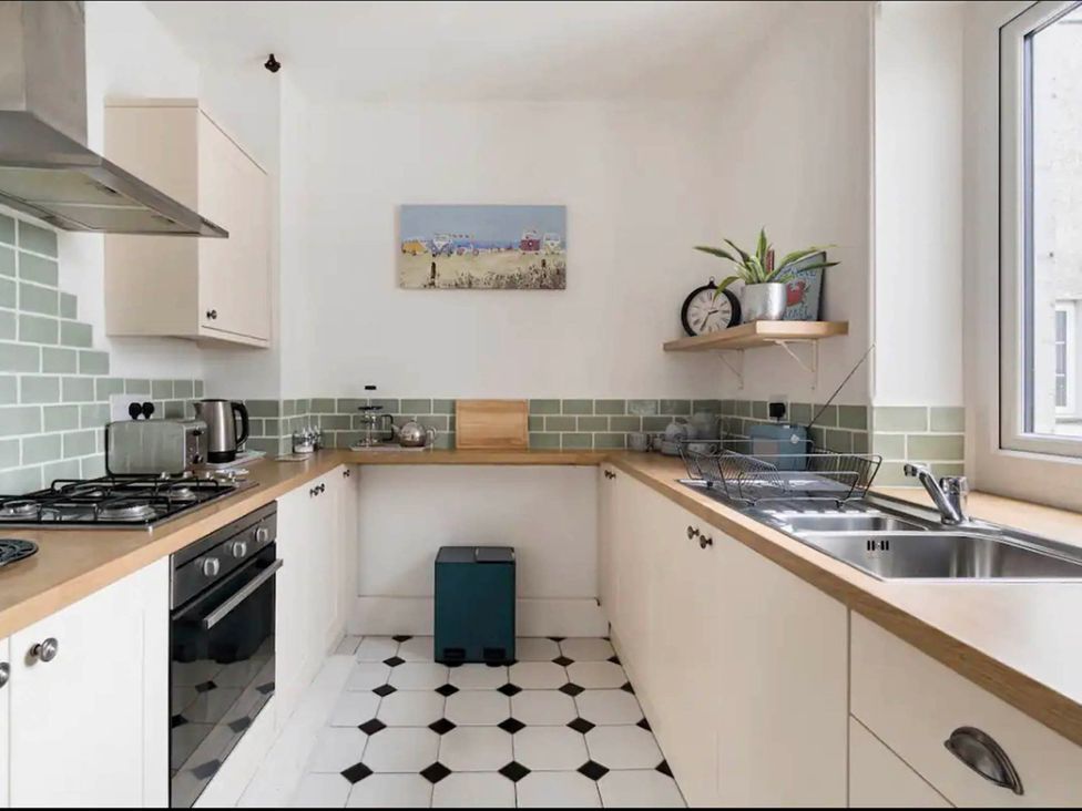 A kitchen with stove, sink, and counter at Beautiful Sea Front Cottage in Plymouth