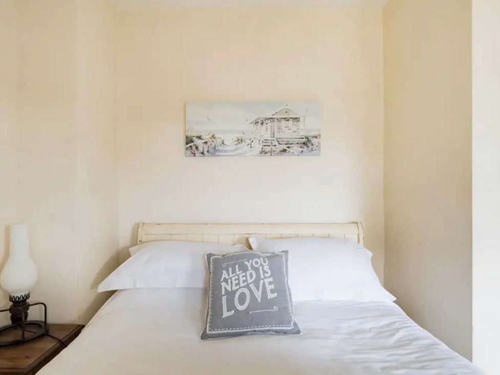 A bedroom with a bed and a lamp at Beautiful Sea Front Cottage in Plymouth