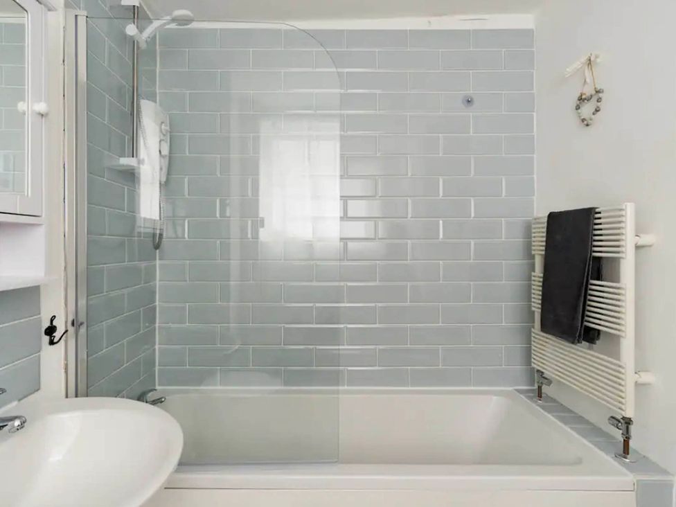 A bathroom with a bathtub and shower at Beautiful Sea Front Cottage in Plymouth