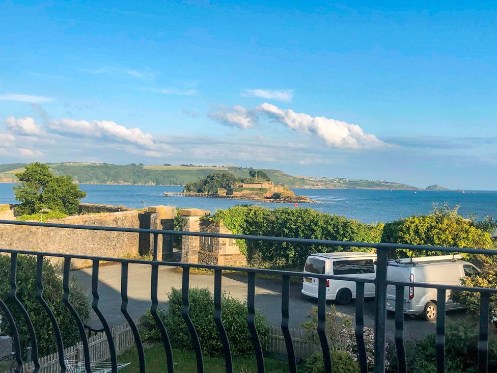 A view of the sea and trees from the outdoor area at Beautiful Sea Front Cottage in Plymouth