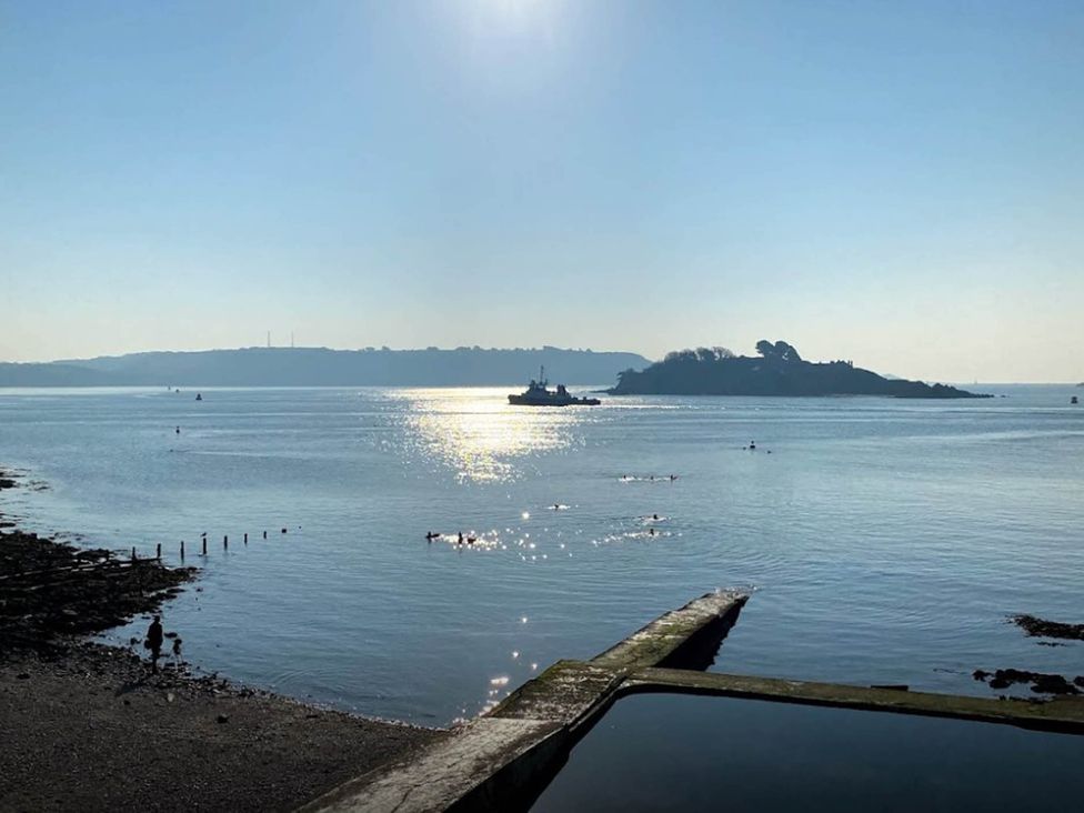 A scenic view of water with an island and boat at Beautiful Sea Front Cottage in Plymouth