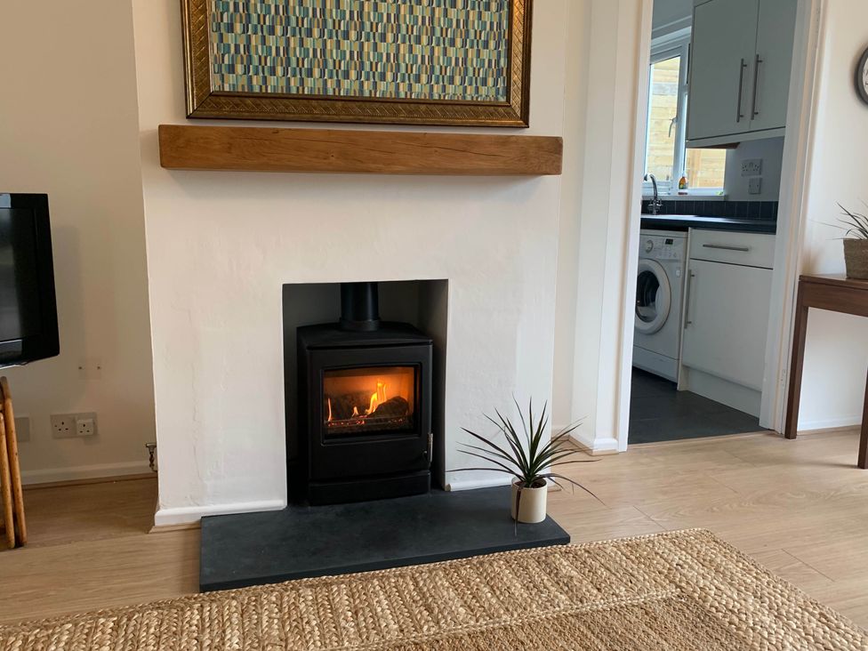 A living room with a fireplace and a view of the kitchen at 2 Bed Sleeps 4 Parking Pets 10 min walk to Beach Falmouth