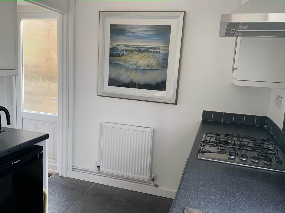 A kitchen with a gas stove and a framed picture at 2 Bed Sleeps 4 Parking Pets 10 min walk to Beach Falmouth