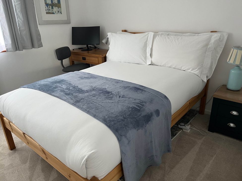 A bedroom with a bed, monitor, and nightstand at 2 Bed Sleeps 4 Parking Pets 10 min walk to Beach Falmouth