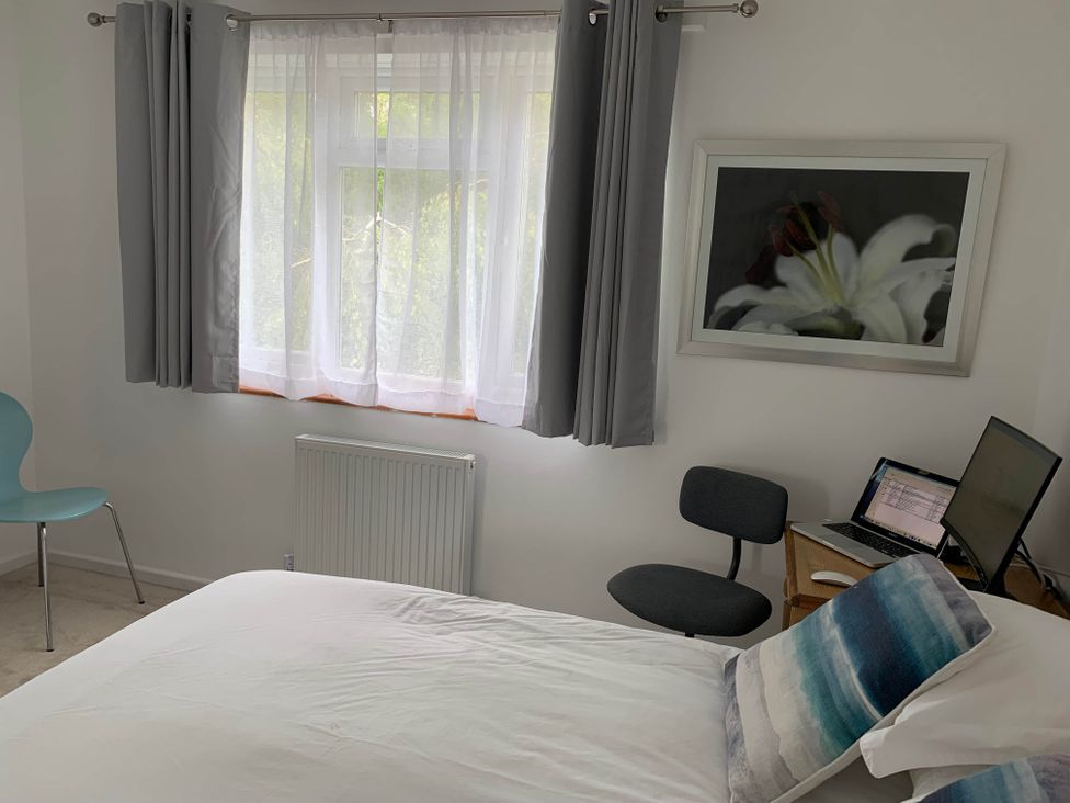 A bedroom with a bed, chair, and computer at 2 Bed Sleeps 4 Parking Pets 10 min walk to Beach Falmouth