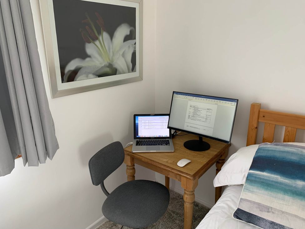 A workspace with a laptop and monitor on a desk in a bedroom at 2 Bed Sleeps 4 Parking Pets 10 min walk to Beach Falmouth