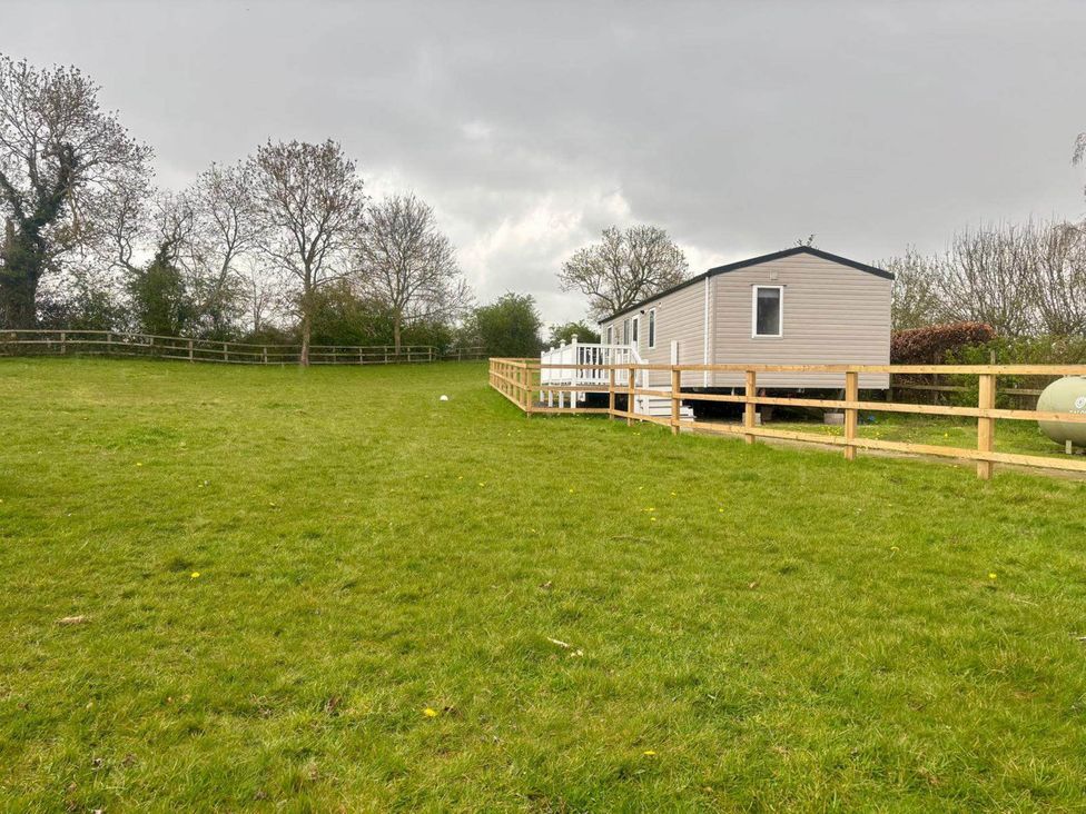A caravan in a grassy area with trees at Caravan in Holcot Sleeps 6 Max 6 people Max 4 adults per booking Pet Friendly, Holcot near Moulton
