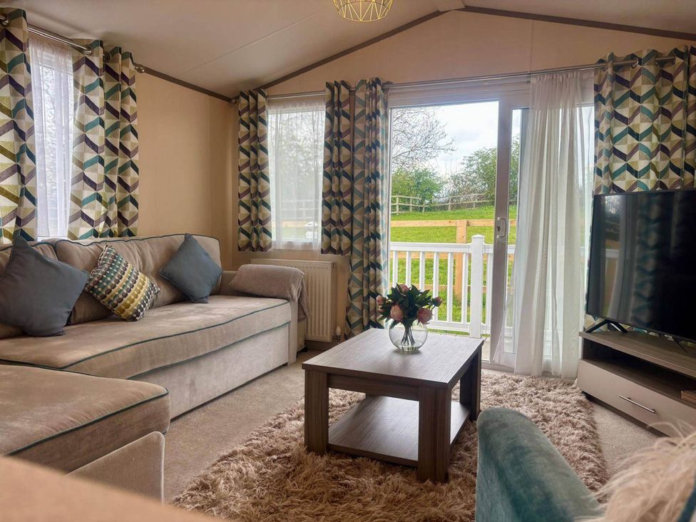 A living room with a sofa and coffee table at Caravan in Holcot Sleeps 6 Max 6 people Max 4 adults per booking Pet Friendly Holcot near Moulton