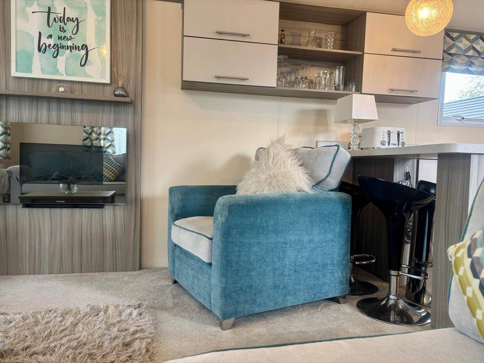 A living room with a chair and television at Caravan in Holcot Sleeps 6 Max 6 people Max 4 adults per booking Pet Friendly Holcot near Moulton