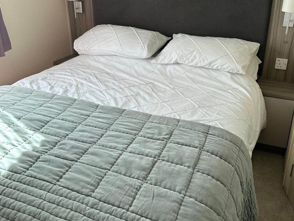 A bedroom with a bed and pillows at Caravan in Holcot Sleeps 6 Max 6 people Max 4 adults per booking Pet Friendly Holcot near Moulton