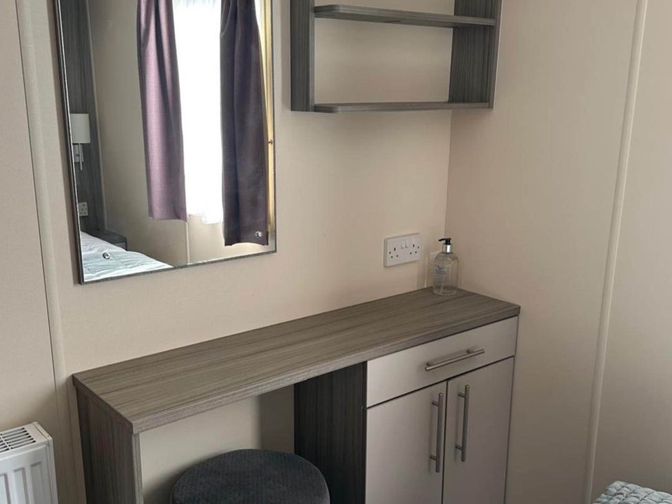 A bedroom with a mirror and a small desk at Caravan in Holcot Sleeps 6 Max 6 people Max 4 adults per booking Pet Friendly Holcot near Moulton