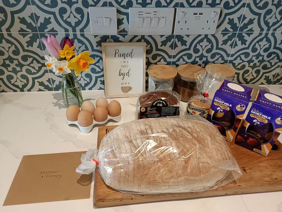 A kitchen counter with eggs, bread, chocolate, and flowers at Aberporth 2 Bed Cottage Sleeps 4 Pet Friendly, Parcllyn near Aberporth