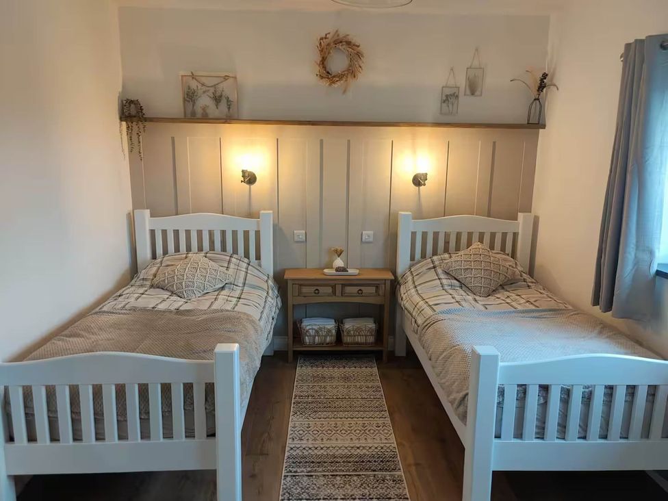 A bedroom with two single beds and a nightstand at Aberporth 2 Bed Cottage Sleeps 4 Pet Friendly Parcllyn near Aberporth