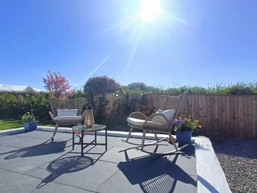 A garden with chairs and a table at Aberporth 2 Bed Cottage Sleeps 4 Pet Friendly Parcllyn near Aberporth