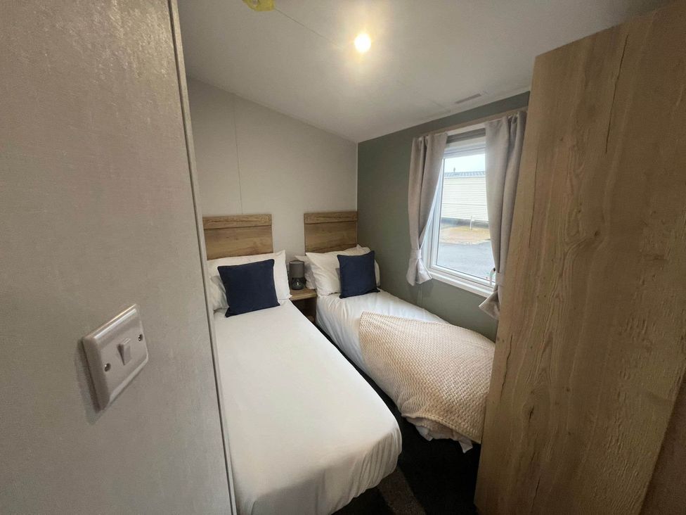 A bedroom with two single beds at 8 Guests Swimming Pool 1min to the Beach Heacham