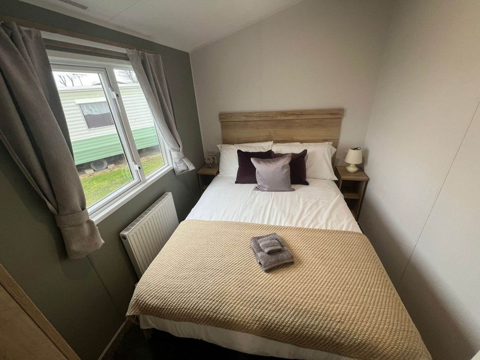 A bedroom with a bed and window at 8 Guests Swimming Pool 1min to the Beach Heacham
