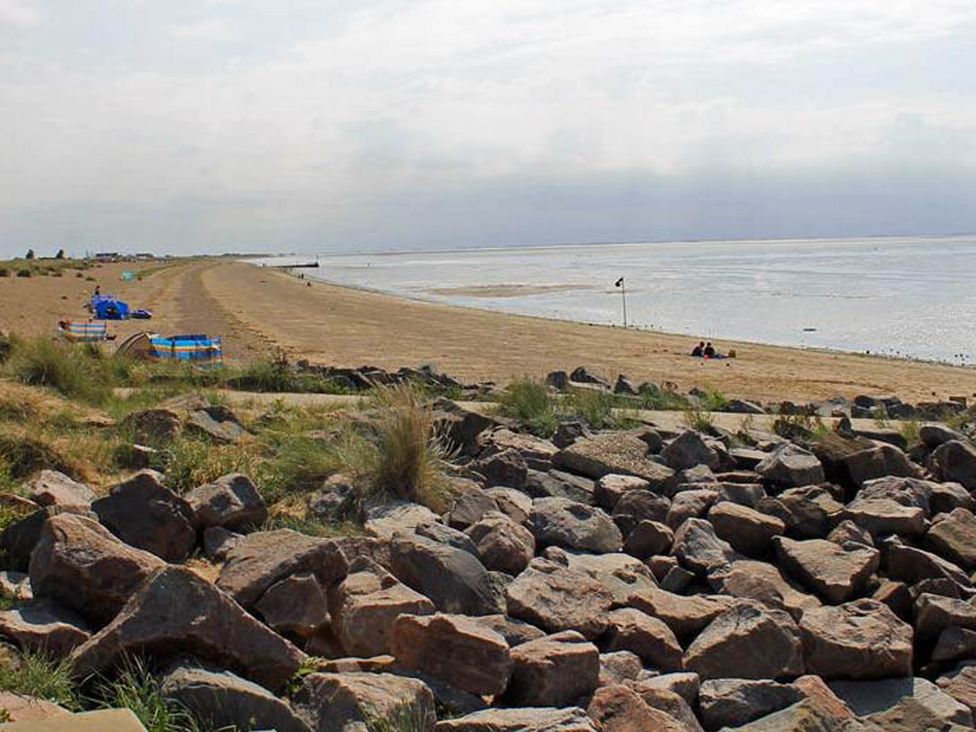 A beach with rocks and water at 8 Guests Swimming Pool 1min to the Beach Heacham