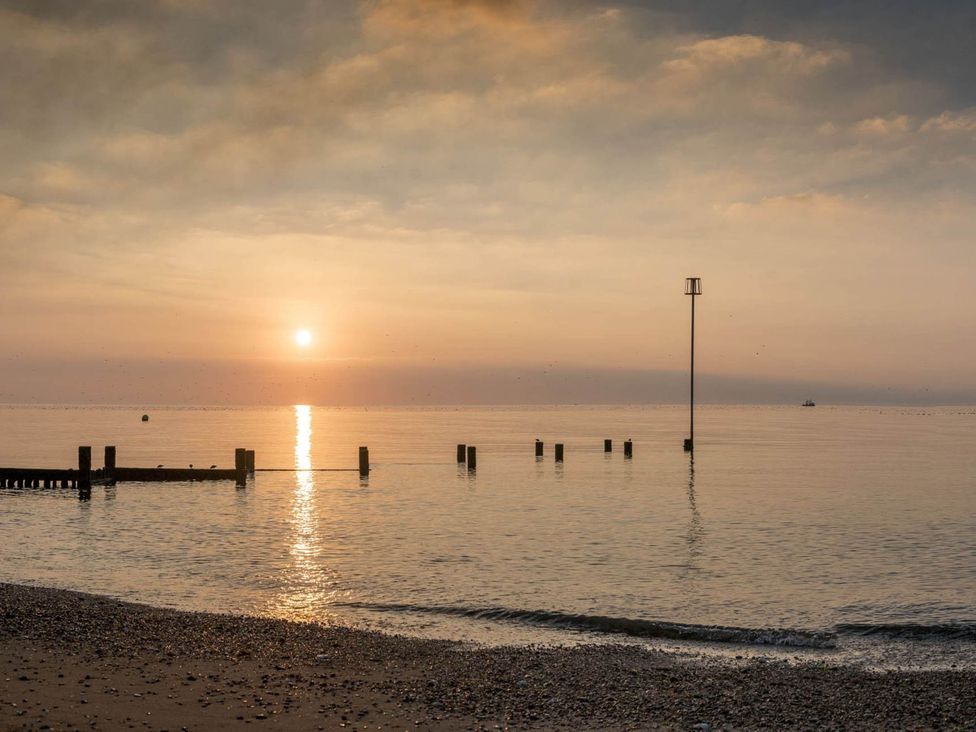 A beach scene with sun setting over the water at 8 Guests Swimming Pool 1min to the Beach Heacham