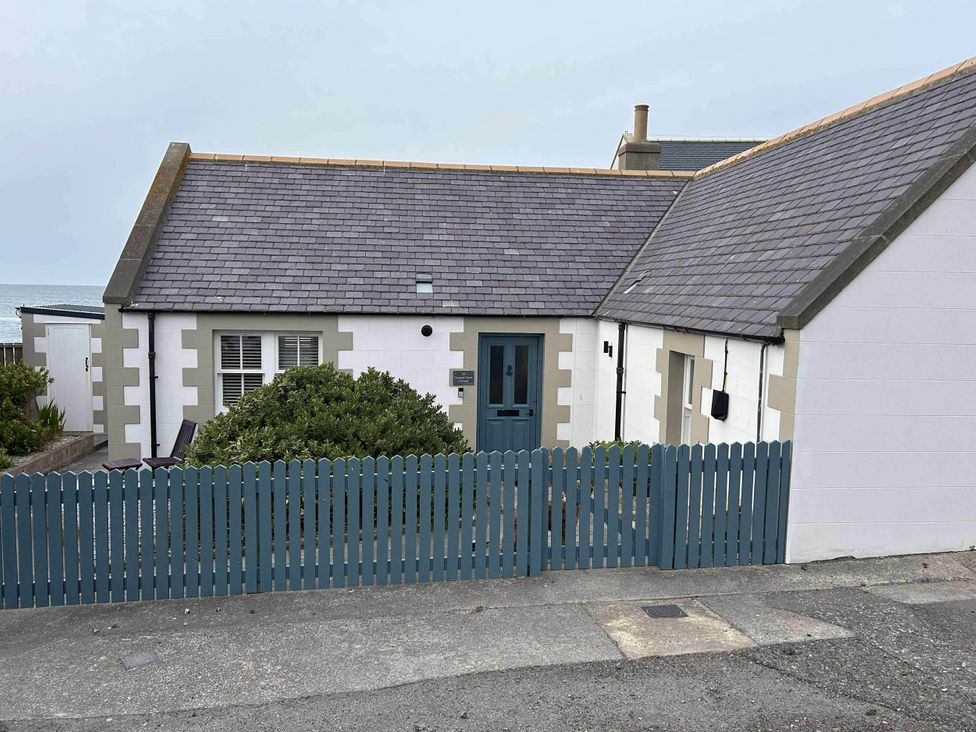 A house with blue door and picket fence at Findochty Beach house Private Garden BeachFront in Findochty