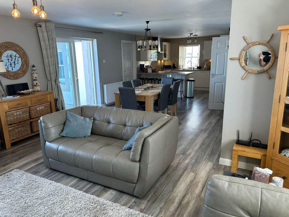 A living room with a sofa, dining table and kitchen area at Findochty Beach house Private Garden BeachFront, Findochty