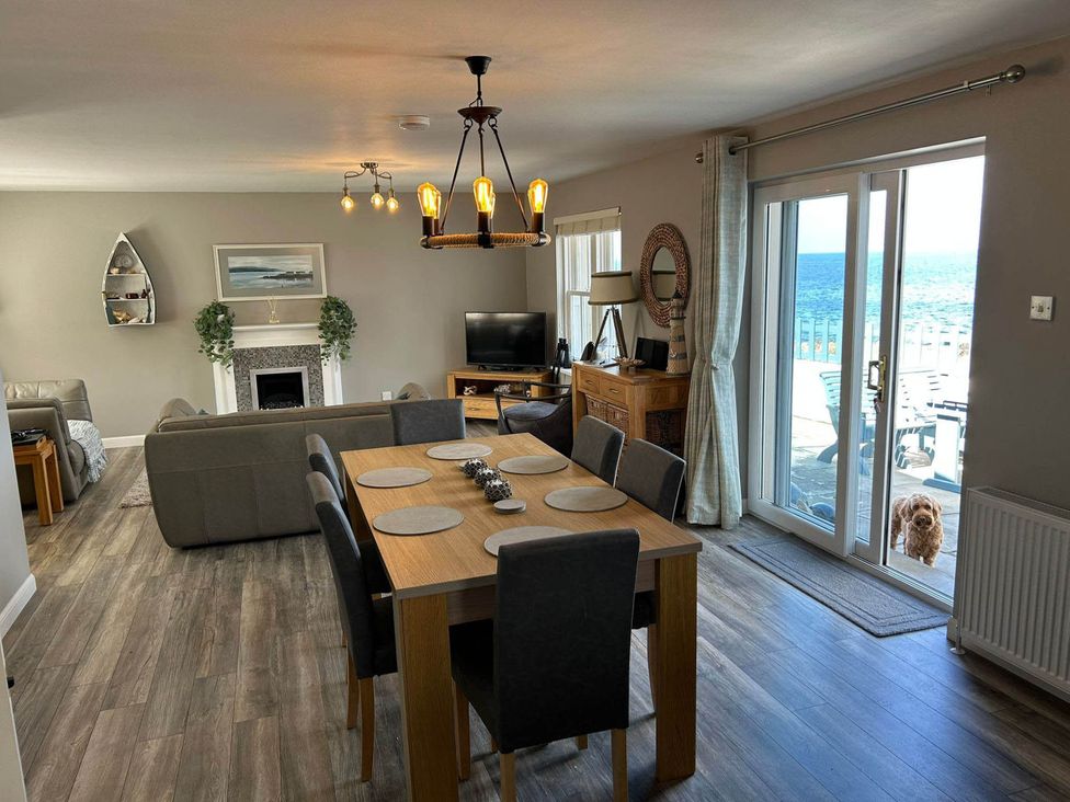 A living room with a dining table and sofa at Findochty Beach house Private Garden BeachFront in Findochty
