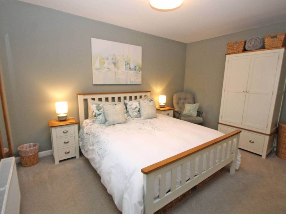 A bedroom with a bed and bedside tables at Findochty Beach house Private Garden BeachFront in Findochty