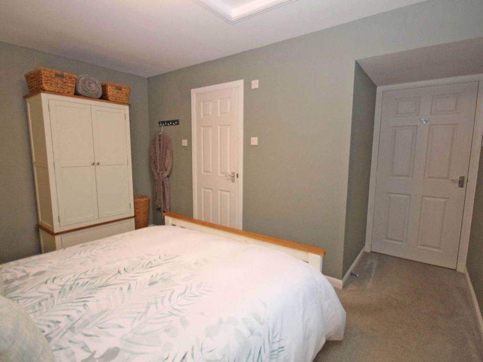 A bedroom with a bed and wardrobe at Findochty Beach house Private Garden BeachFront, Findochty