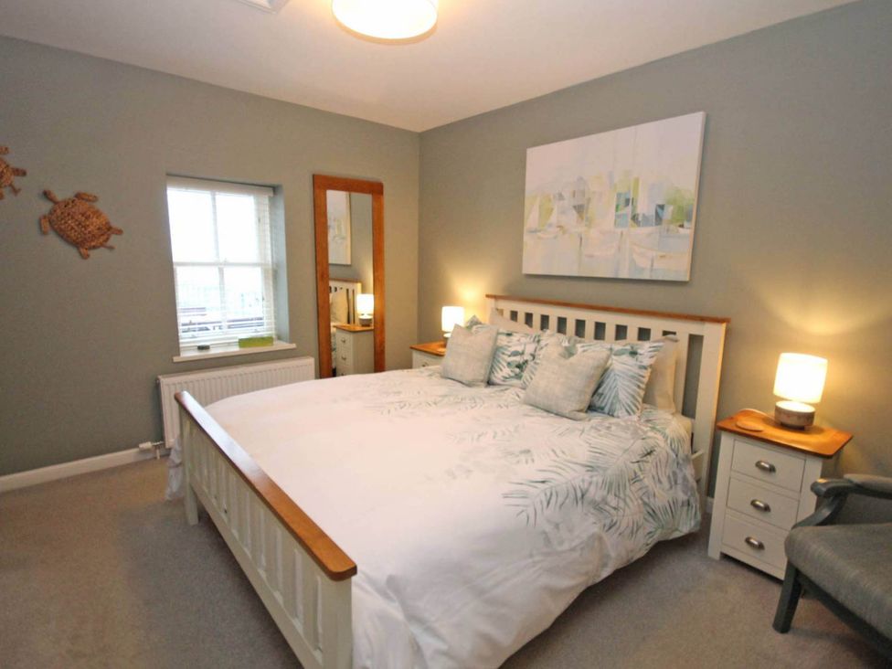 A bedroom with a bed and bedside tables at Findochty Beach house Private Garden BeachFront in Findochty
