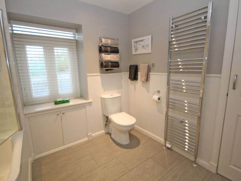 A bathroom with a toilet and towel rack at Findochty Beach house Private Garden BeachFront in Findochty