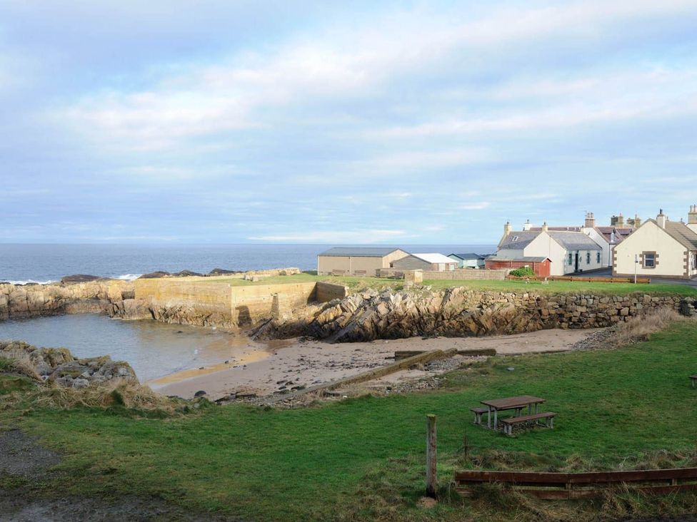 A coastal scene with houses and a sandy shore at Findochty Beach house Private Garden BeachFront in Findochty