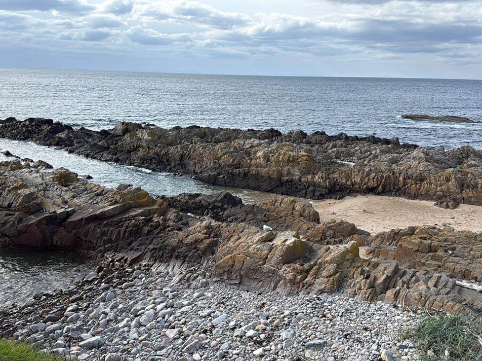 A rocky shoreline with pebbles and sand at Findochty Beach house Private Garden BeachFront in Findochty