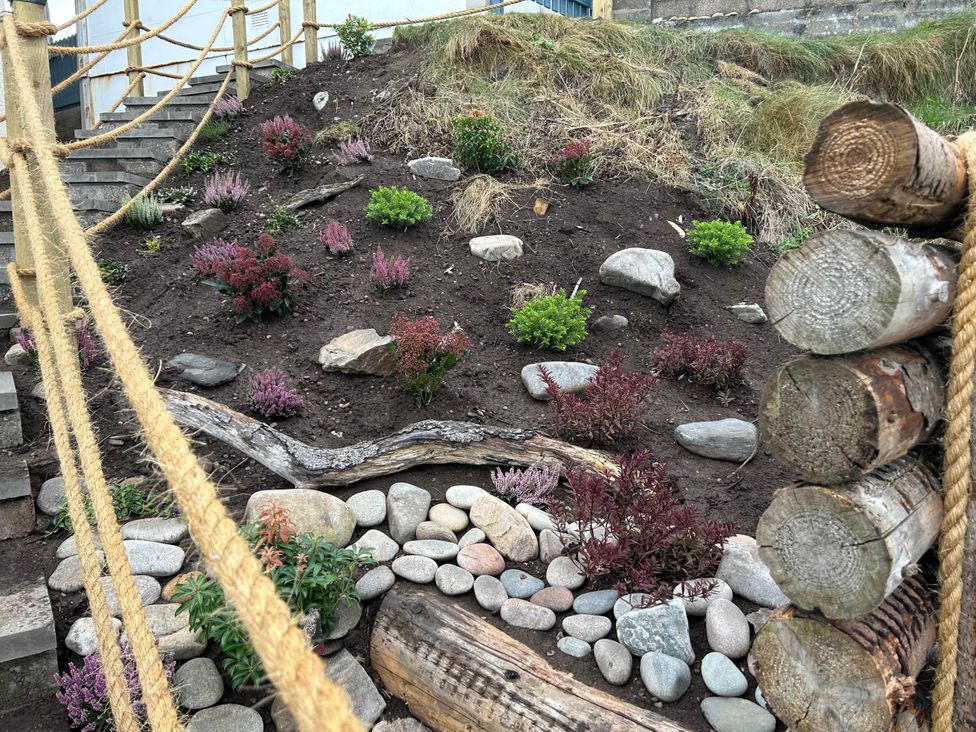 A garden with plants and stones at Findochty Beach house Private Garden BeachFront, Findochty