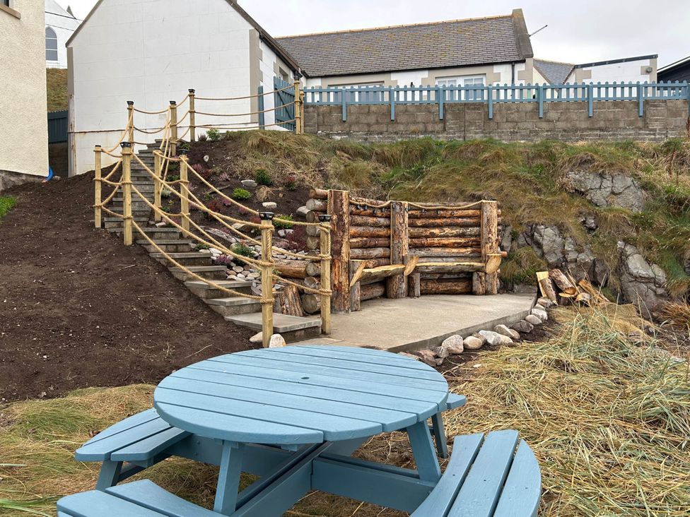 An outdoor area with a step ladder, fence, and wooden seating at Findochty Beach house Private Garden BeachFront in Findochty