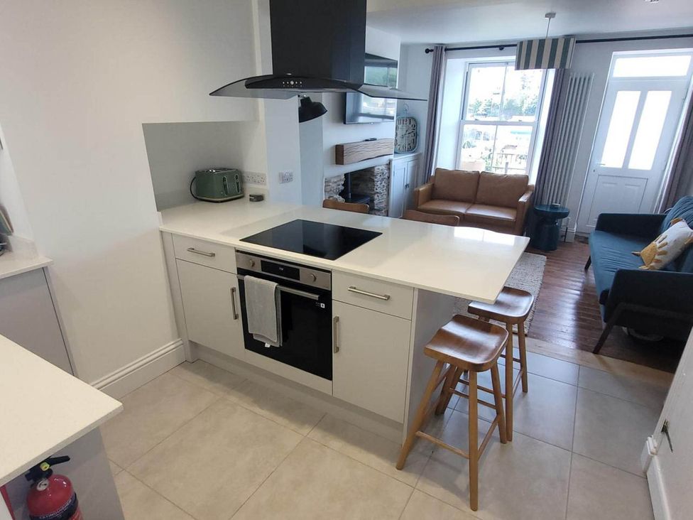 A kitchen with an oven and bar stools at Looe Cottage Seaside views log fire sleeps 4 in Looe
