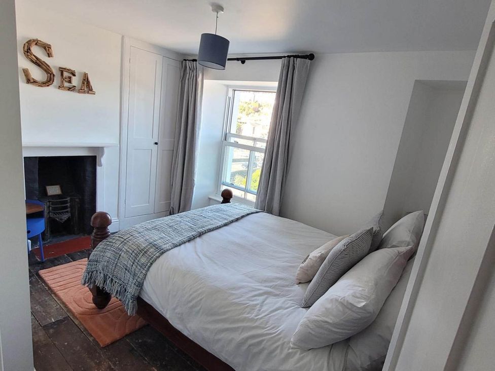 A bedroom with a bed and window at Looe Cottage Seaside views log fire sleeps 4 in Looe