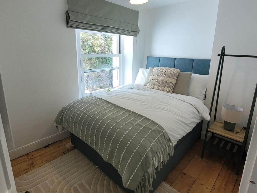 A bedroom with a bed and nightstand at Looe Cottage Seaside views log fire sleeps 4 in Looe