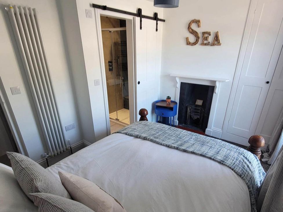 A bedroom with a bed and an attached bathroom at Looe Cottage Seaside views log fire sleeps 4 in Looe