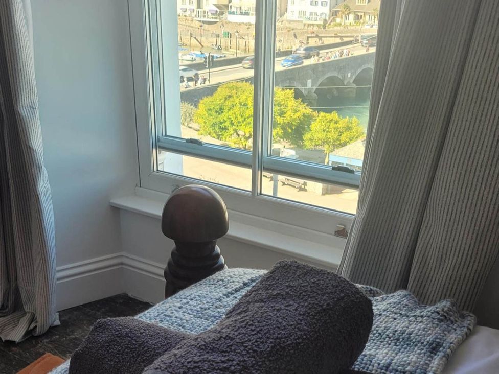 A view from a bedroom window with a towel on a bed at Looe Cottage Seaside views log fire sleeps 4 in Looe