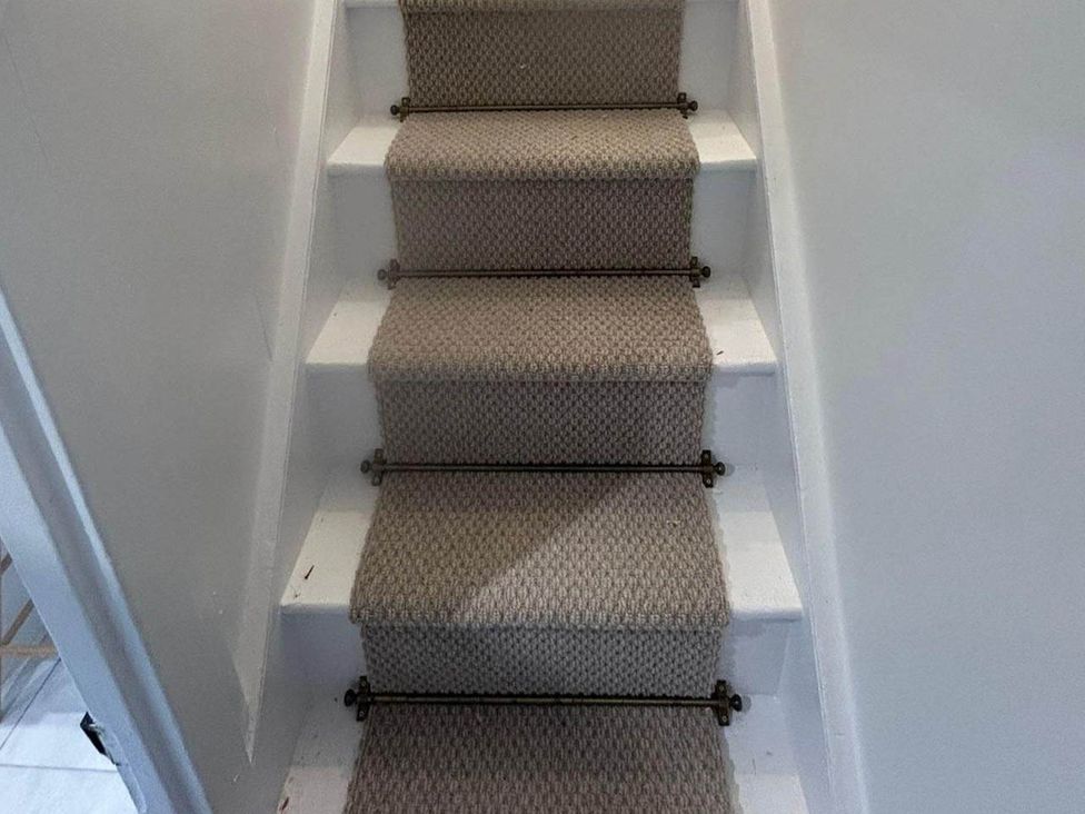 A stairway with carpeted steps at Looe Cottage Seaside views log fire sleeps 4 in Looe